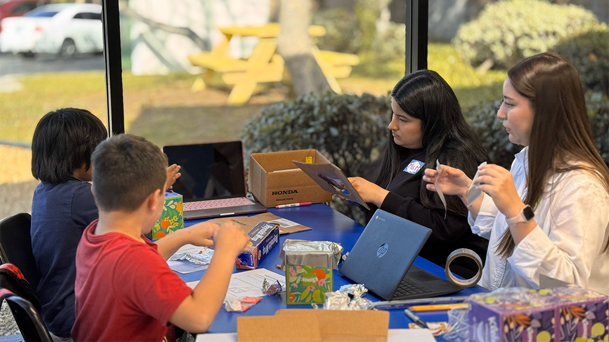 young learners engaged in a science activity with teachers