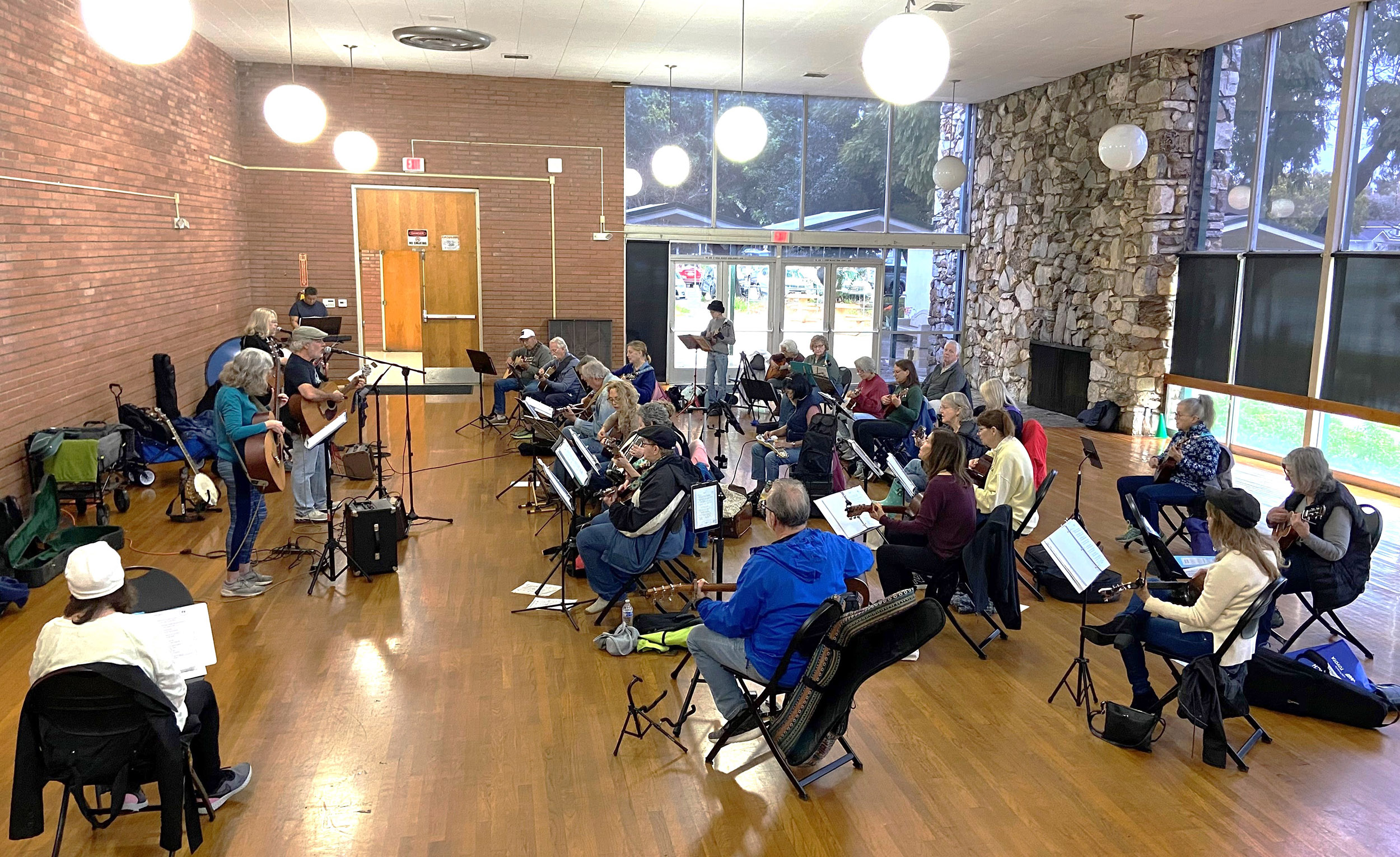 A large group of people playing acoustic guitars A large group of people playing acoustic guitars