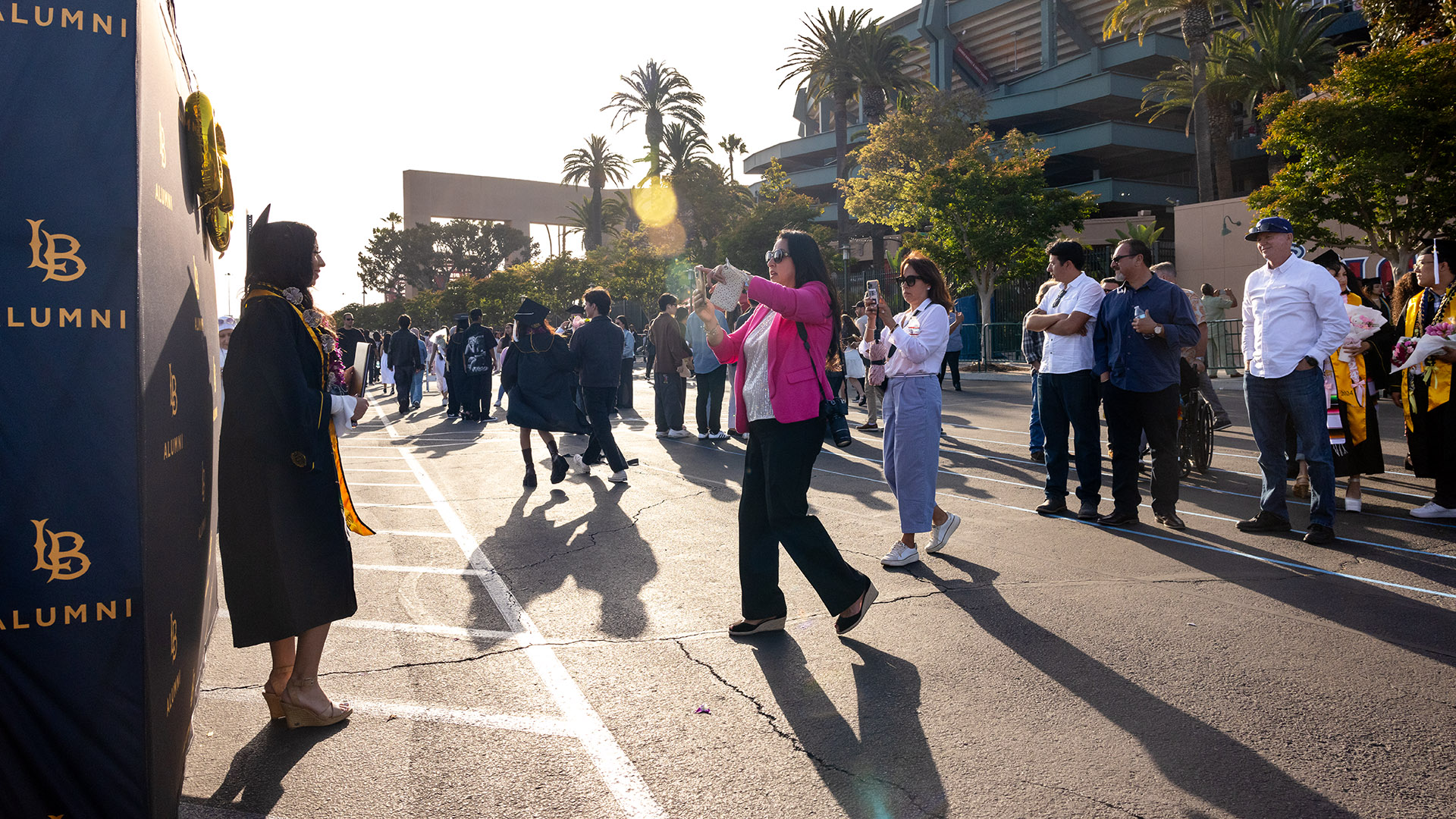 A 2024 CSULB grad has her picture taken following Commencement at Angel's Stadium
