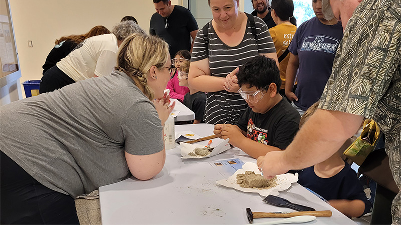 geologist and young child uncovering hidden fossil