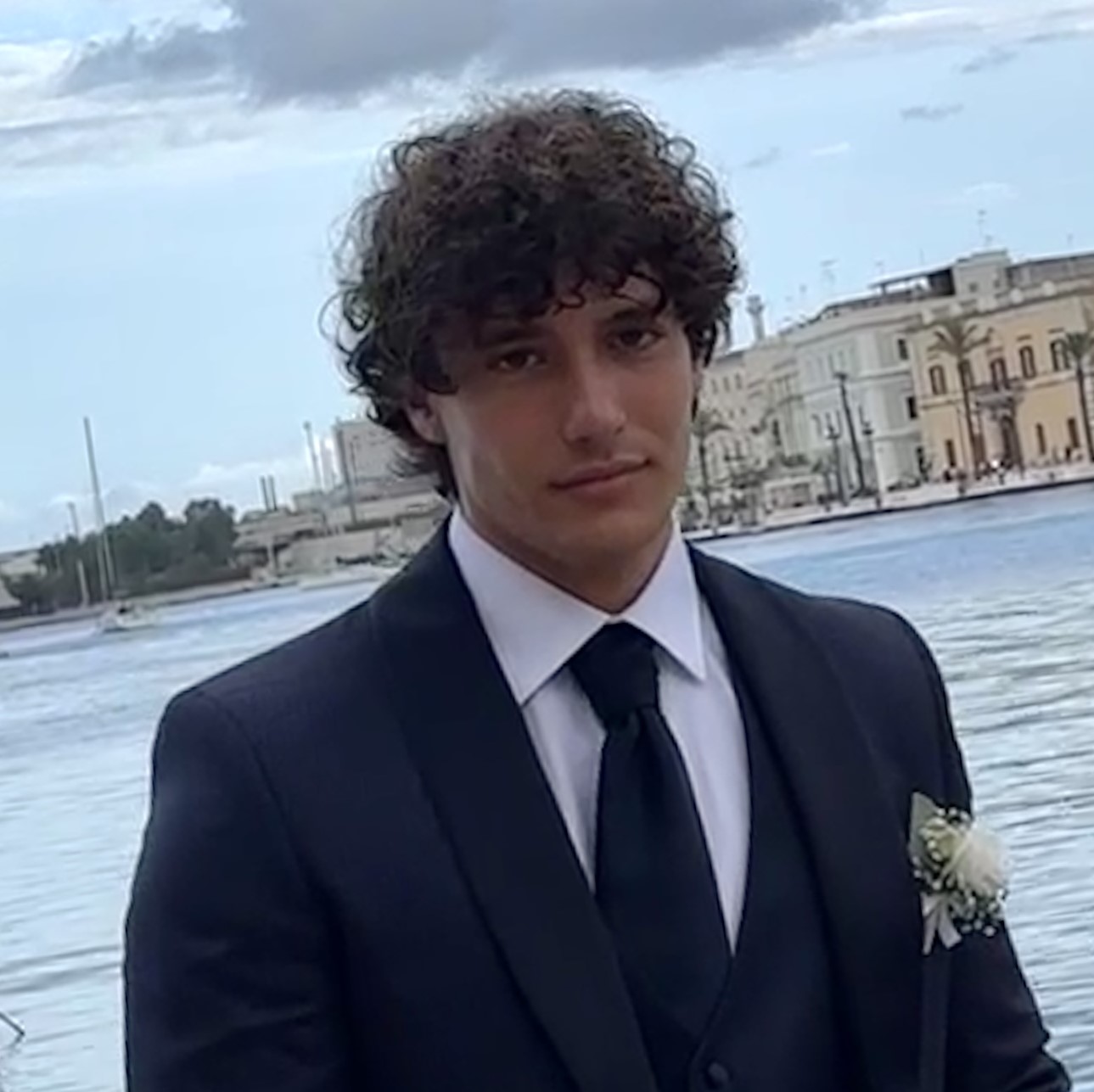 Davide Laudadio headshot male in suit standing in front of water