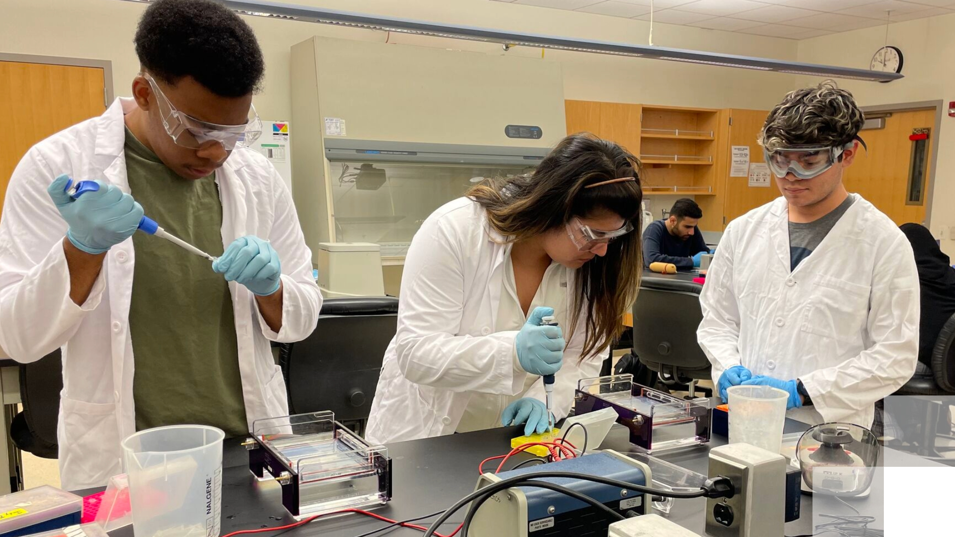Keck Undergraduate Research Experiences (KURE) at CSULB Students in white coats conduct chemistry experiments.