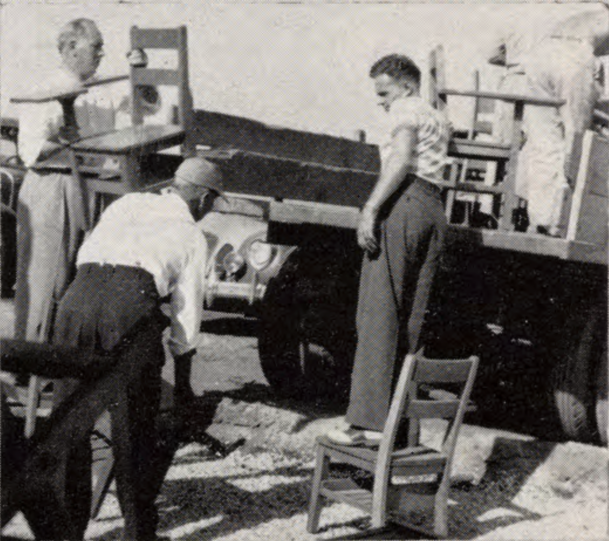 Furniture made at San Quinten Stat Prison Three men unload chairs from a flatbed truck parked outside.