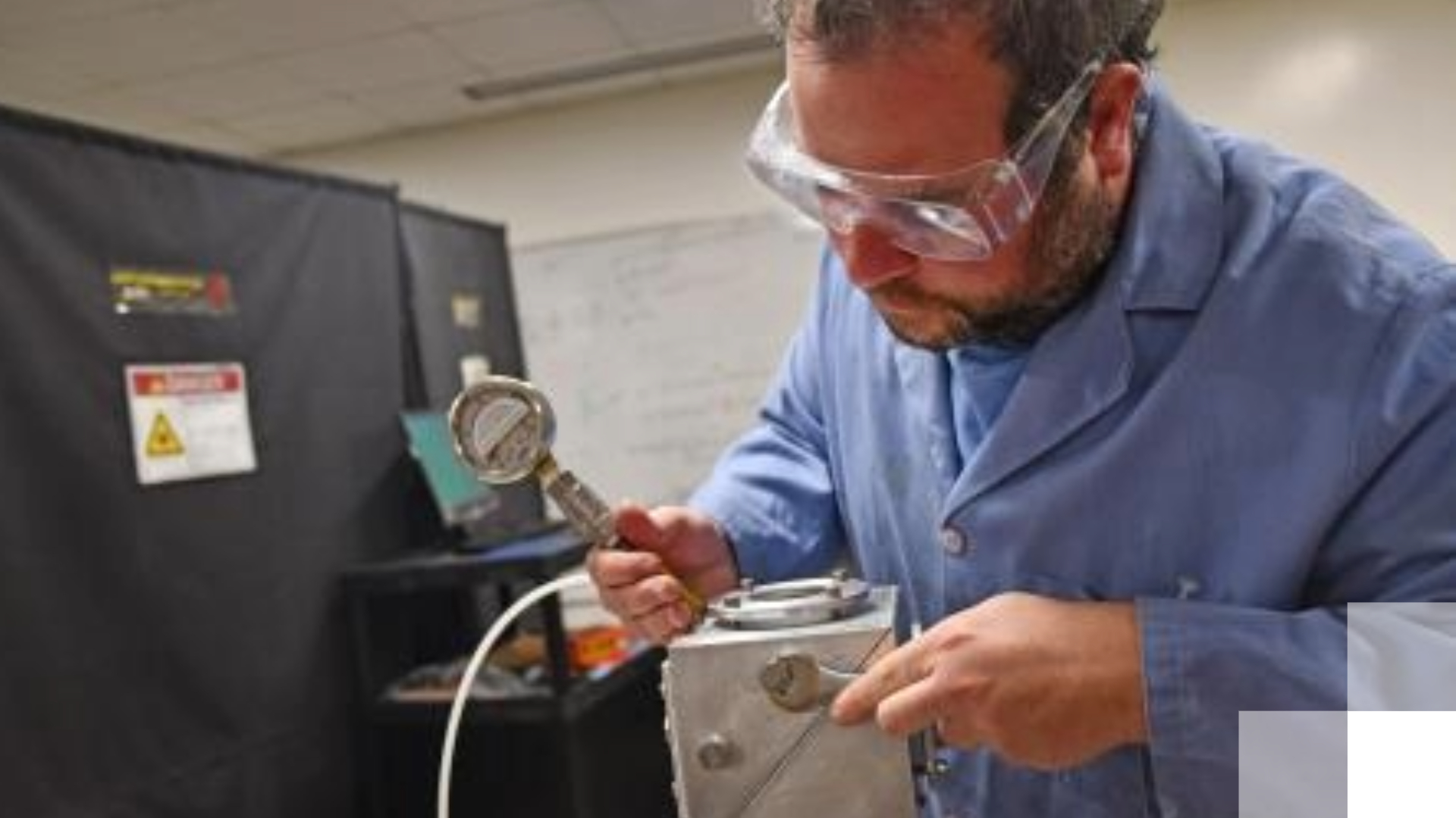 Kalman CAREER grant A professor wearing safety goggles conducts research.