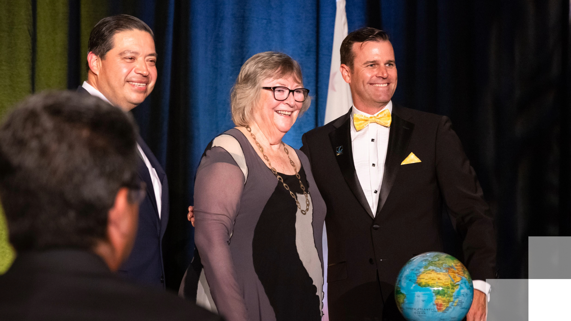 No Barriers campaign Three adults smile on a stage.