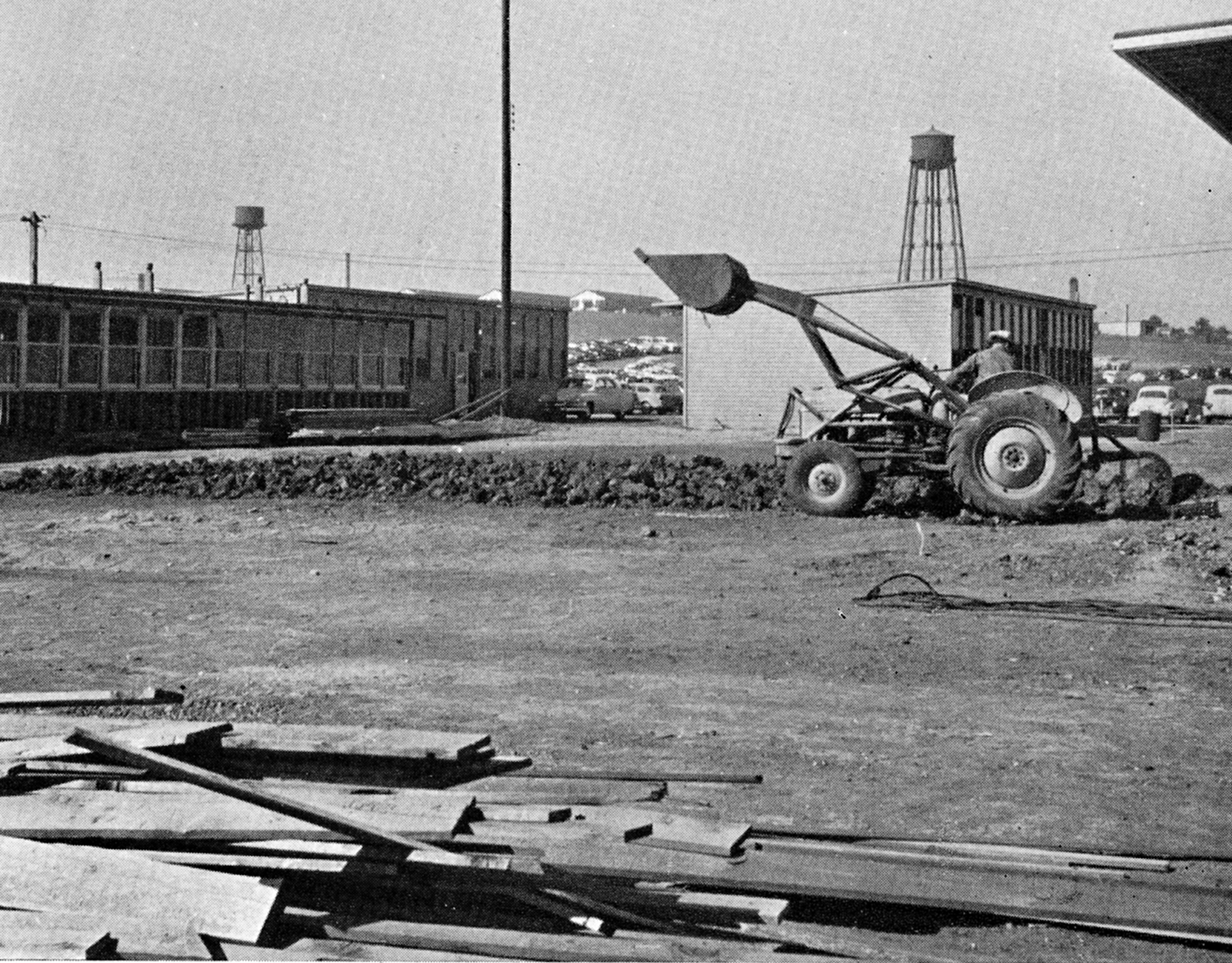 Construction on campus in 1951 A tractor moves dirt near temporary buildings, with two water towers in the background.