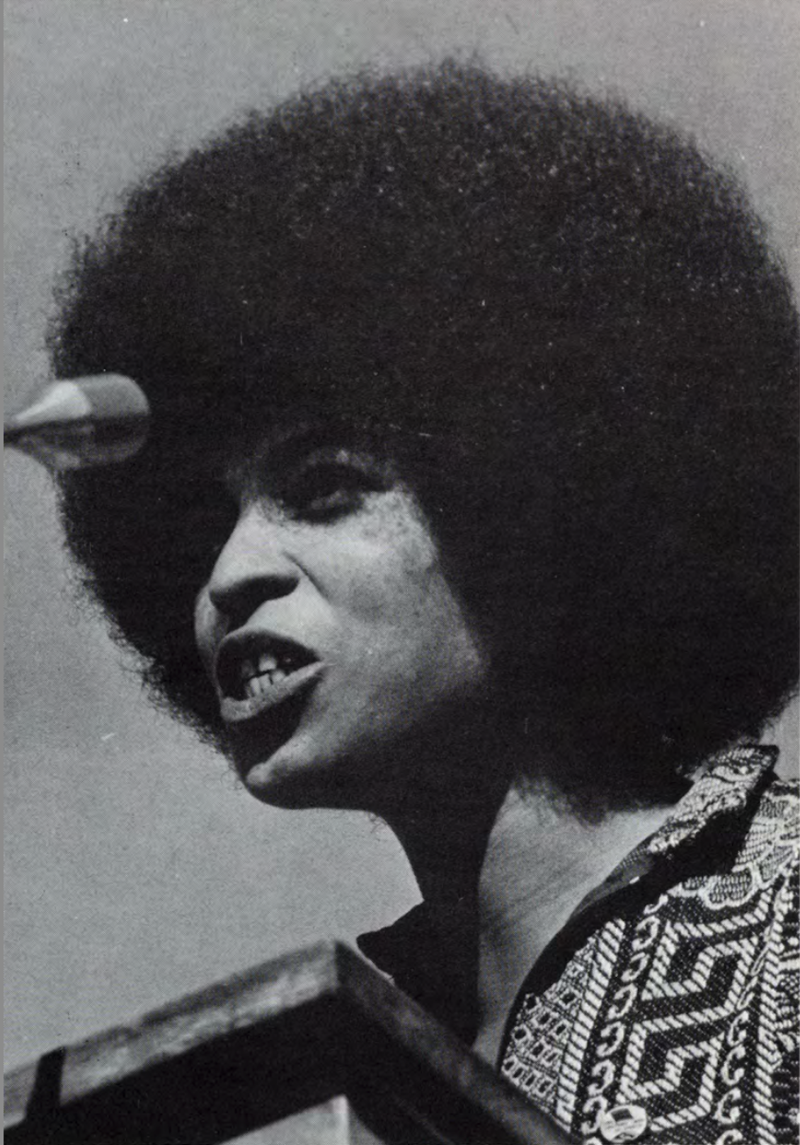 Angela Davis passionately addresses a crowd on campus. Angela Davis passionately addresses a crowd at a microphone.