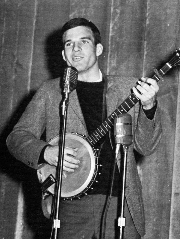 Steve Martin plays the banjo on campus in 1965 Steve Martin plays the banjo and sings into a microphone on stage.