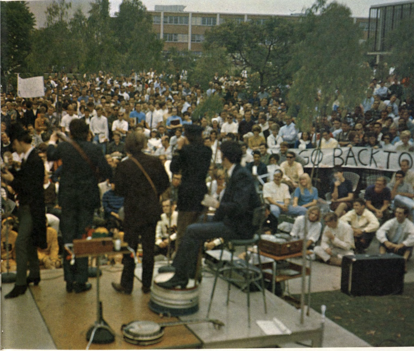 Nitty Gritty Dirt Band play at CSULB A band performs on a small stage in front of a large crowd outdoors.