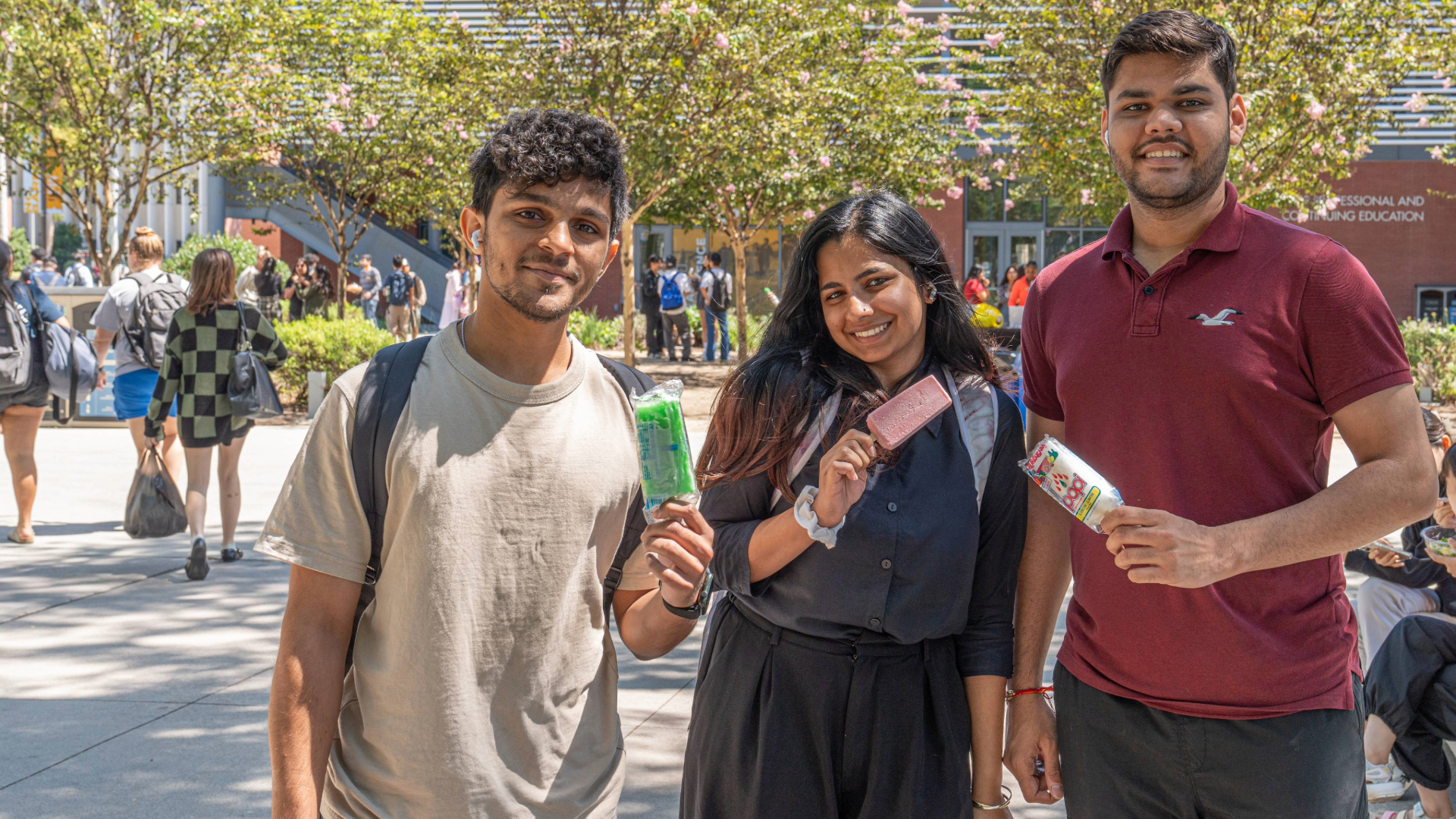 Beach XP Fun Theory Three students smile while eating popsicles.