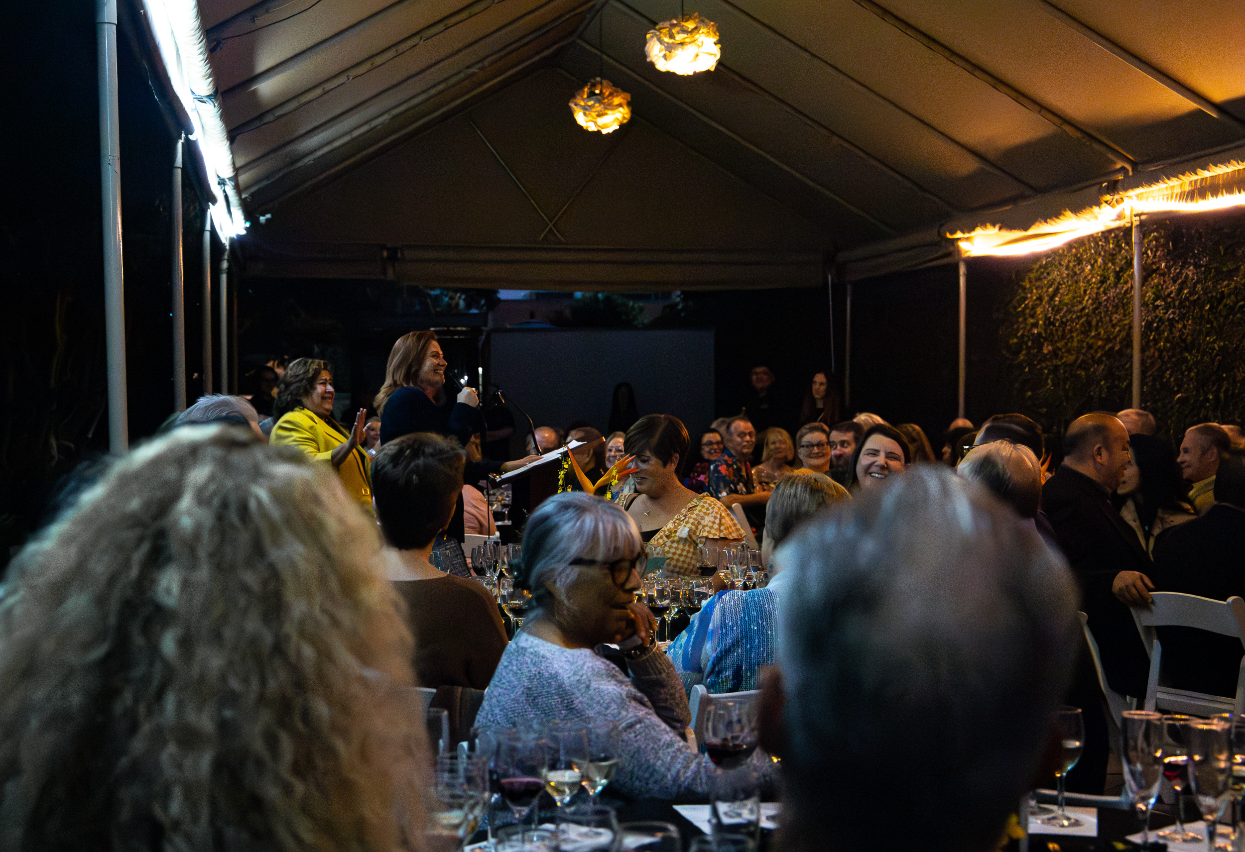 Speakers at a CHHS Culinary and Wine Event Speakers in a tented room with tables full of people