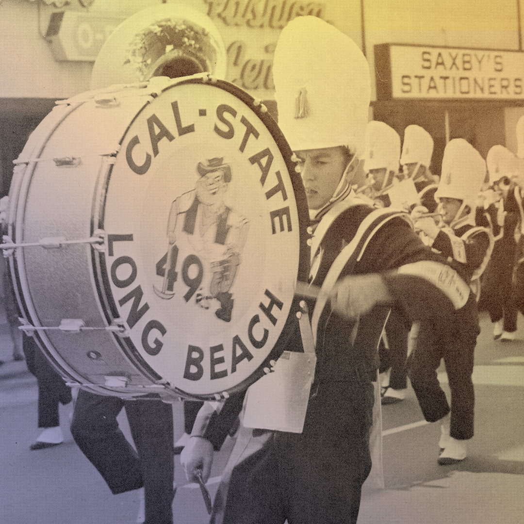 A drummer and marching band on a city street A drummer and marching band on a city street