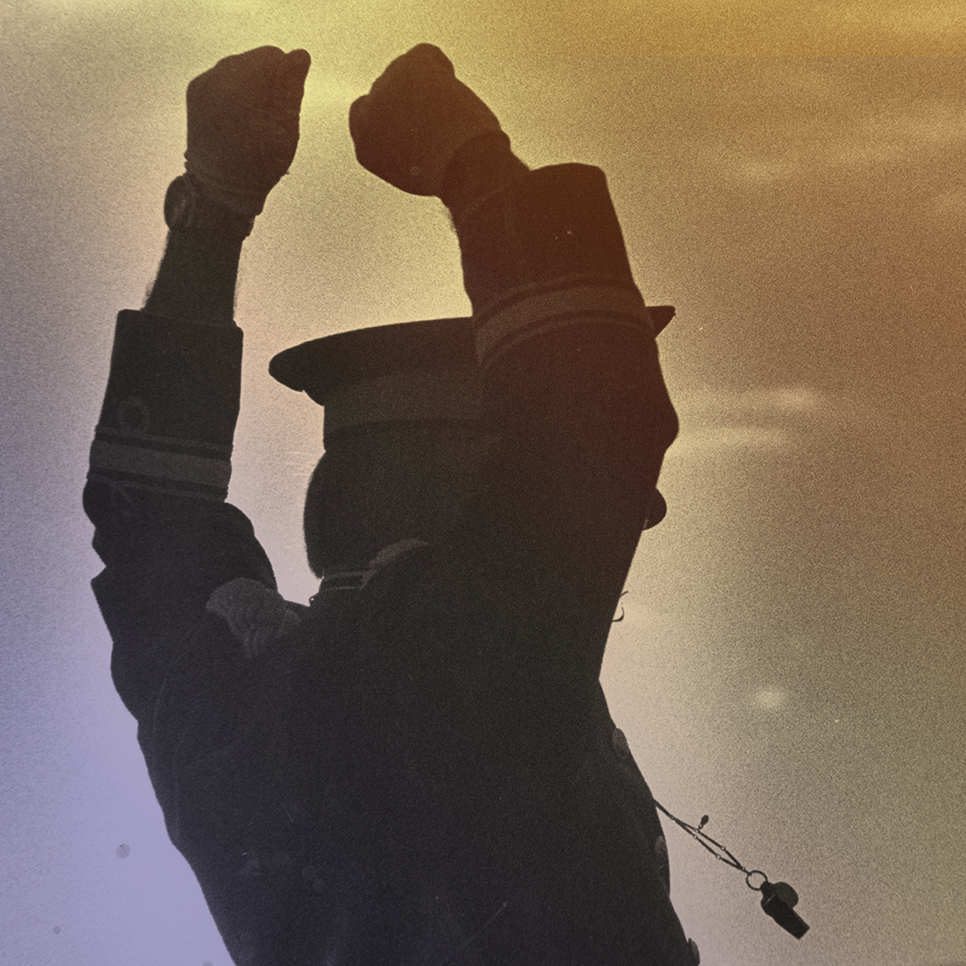 A marching band conductor with arms raised, backlit A marching band conductor with arms raised, backlit