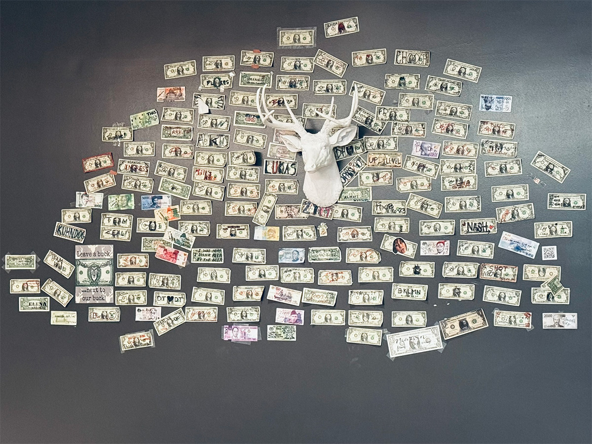 numerous dollar bills taped to wall
