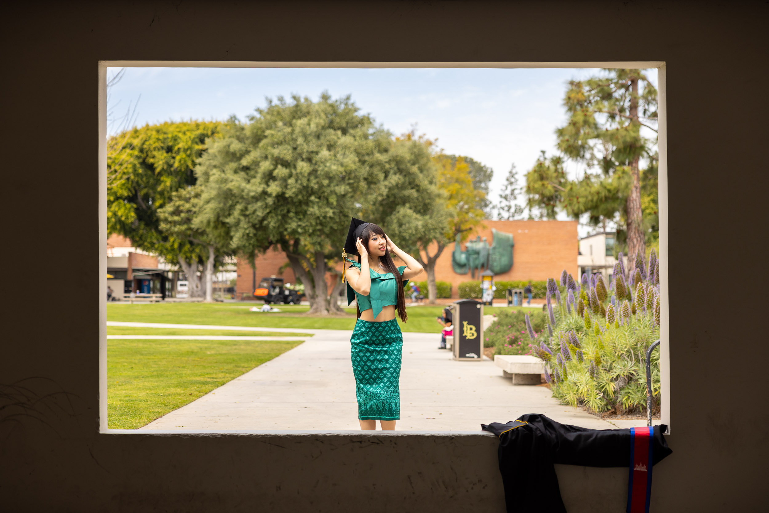 A female student poses with a graduation cap at CSULB's Window Wall