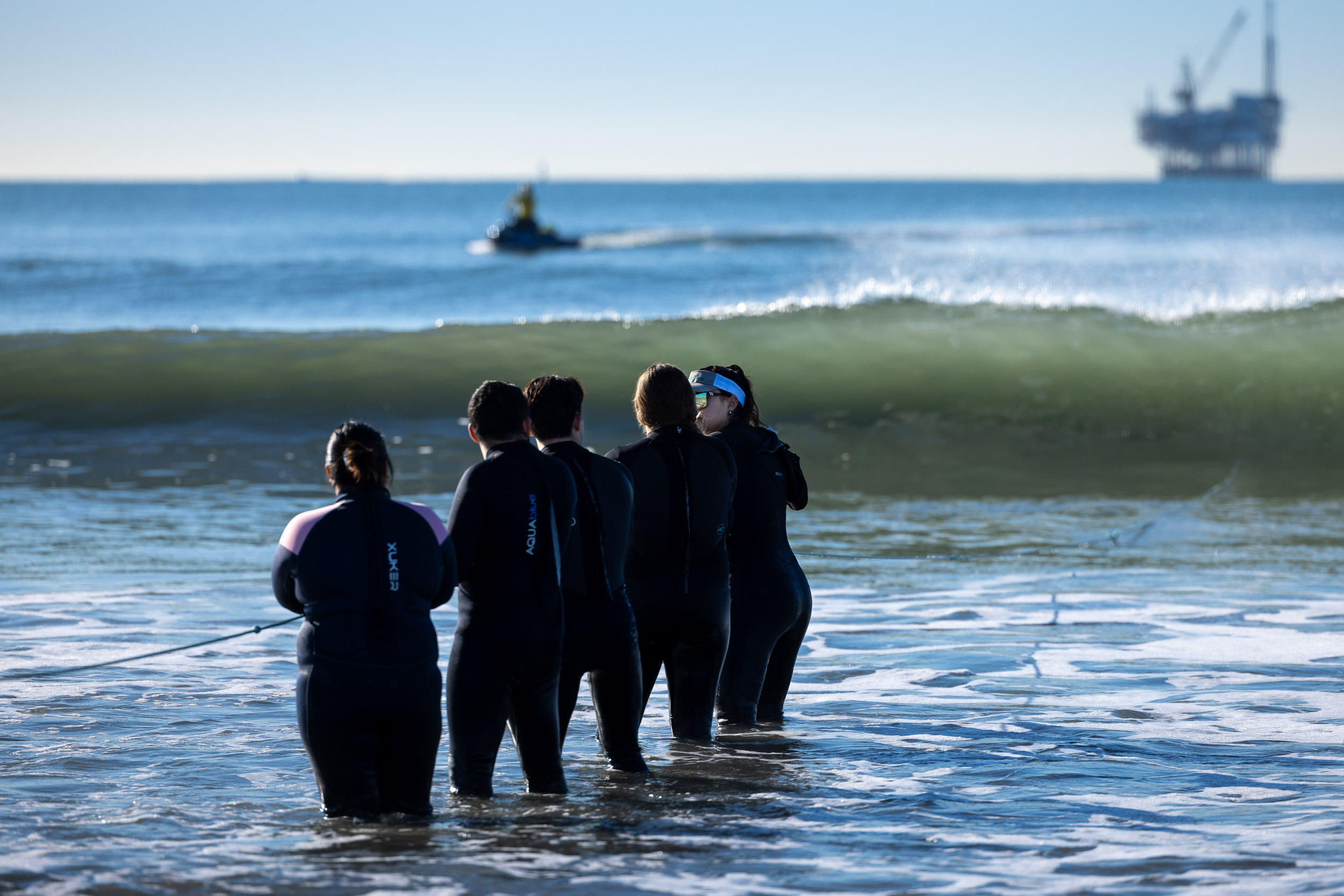 CSULB students standing on beach