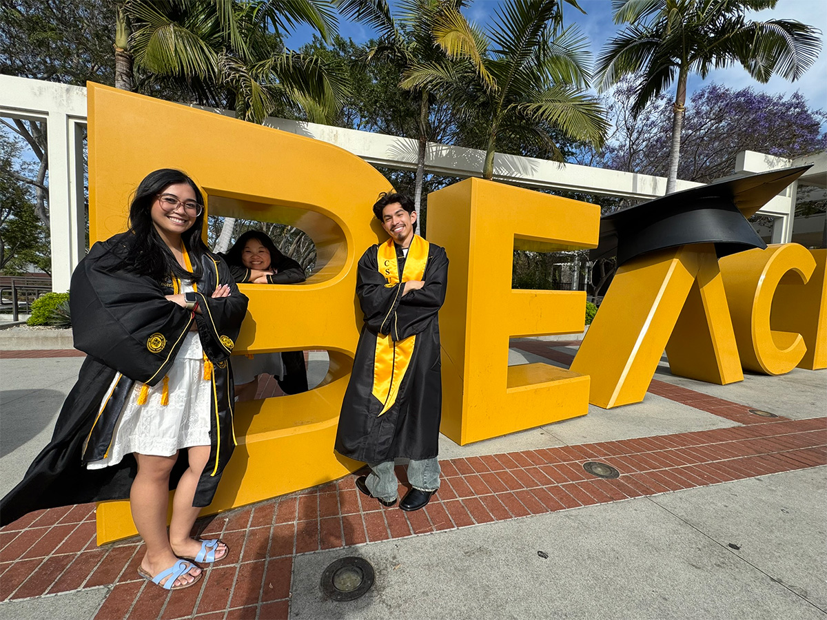 CECS graduates in front of Go Beach sign