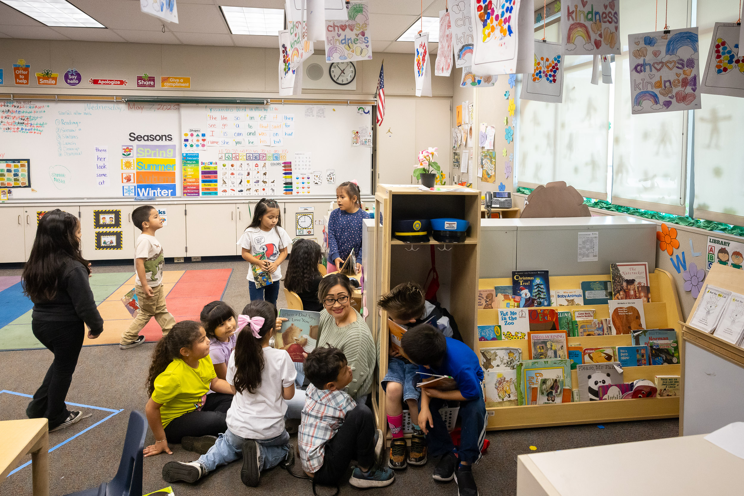 A teacher showing a picture book to children