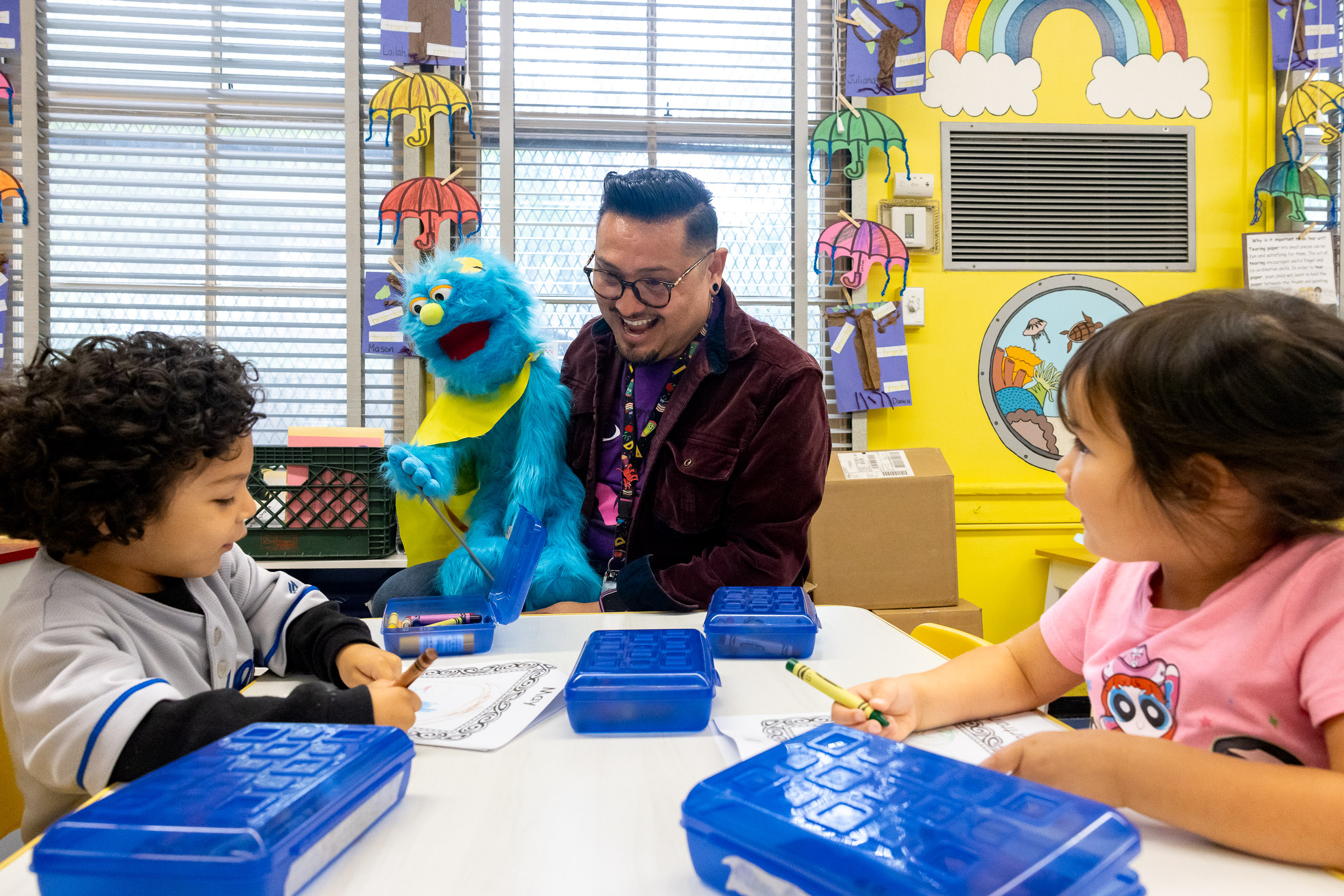 A teacher with a puppet talking to children