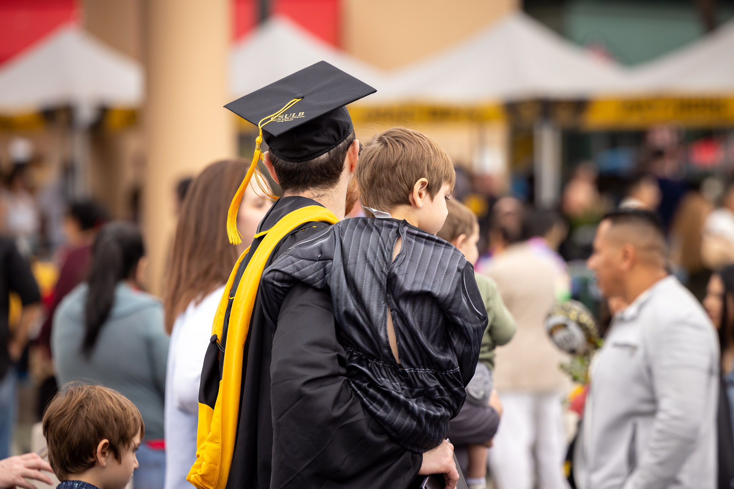 graduating student holds child