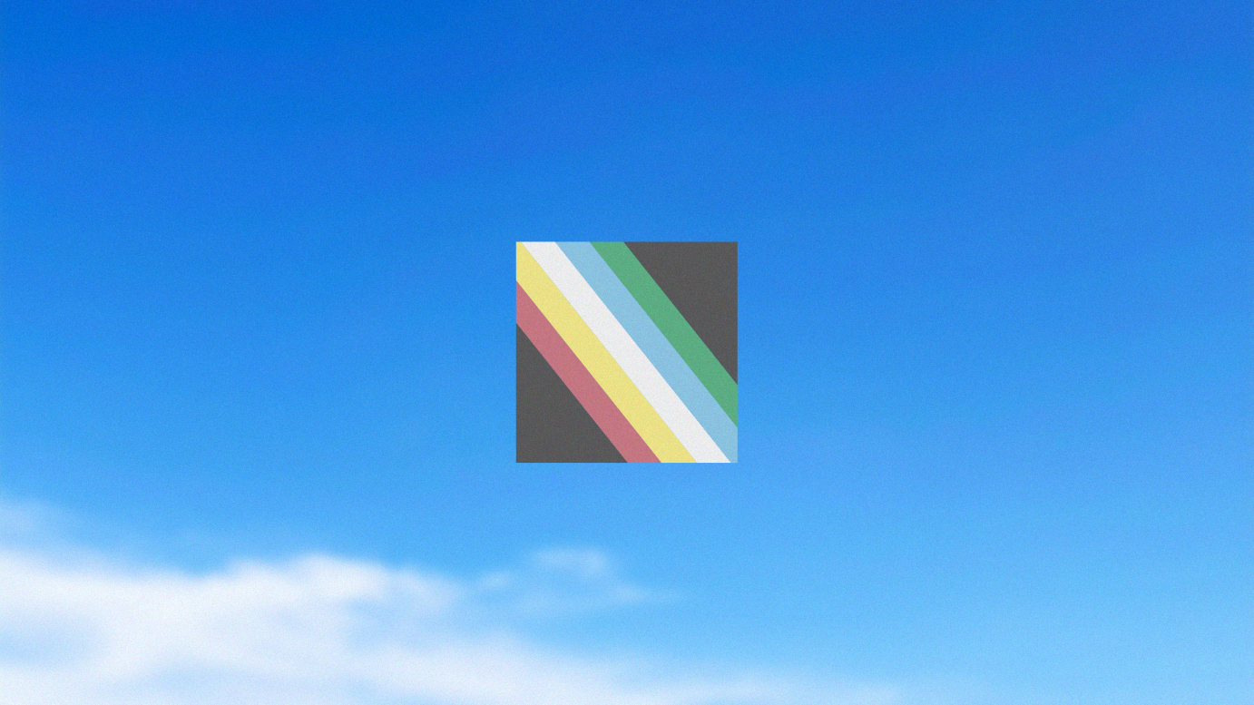 Disability Pride Flag against a blue sky. Please read caption.