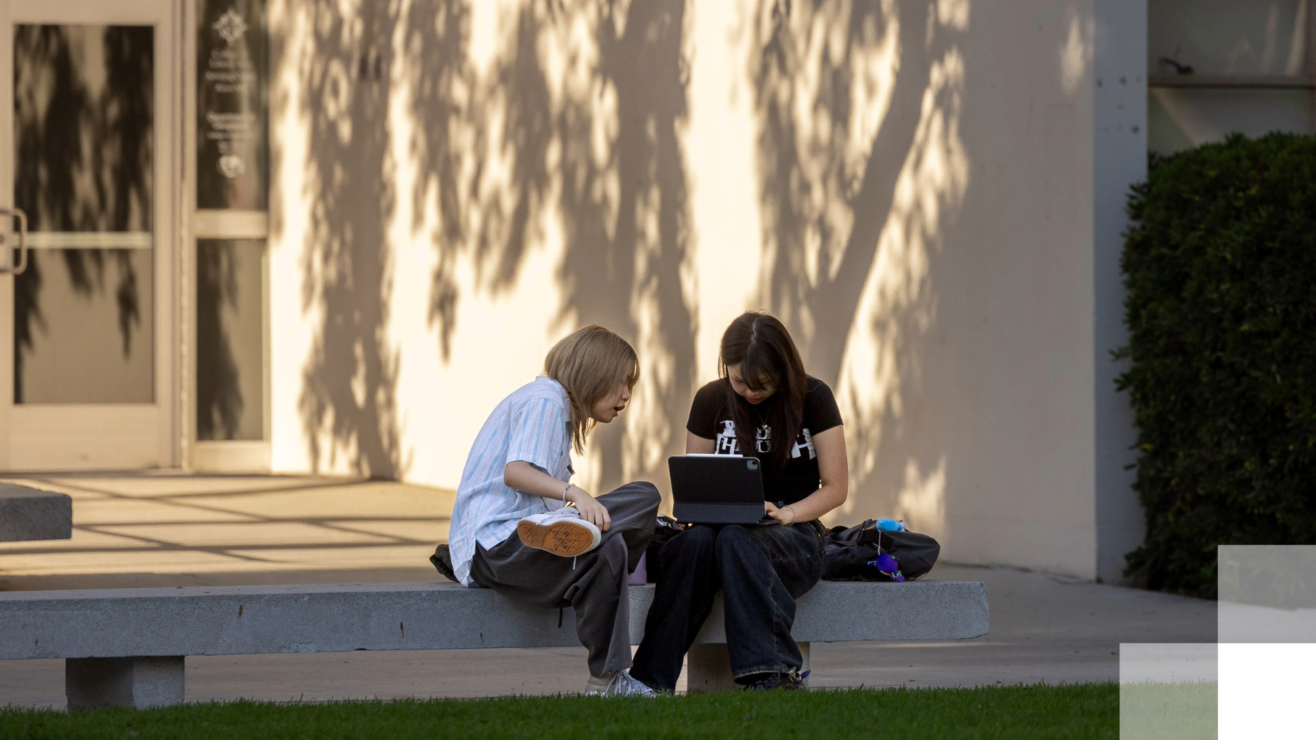 AI Tools Two students sitting on a bench looking at a tablet