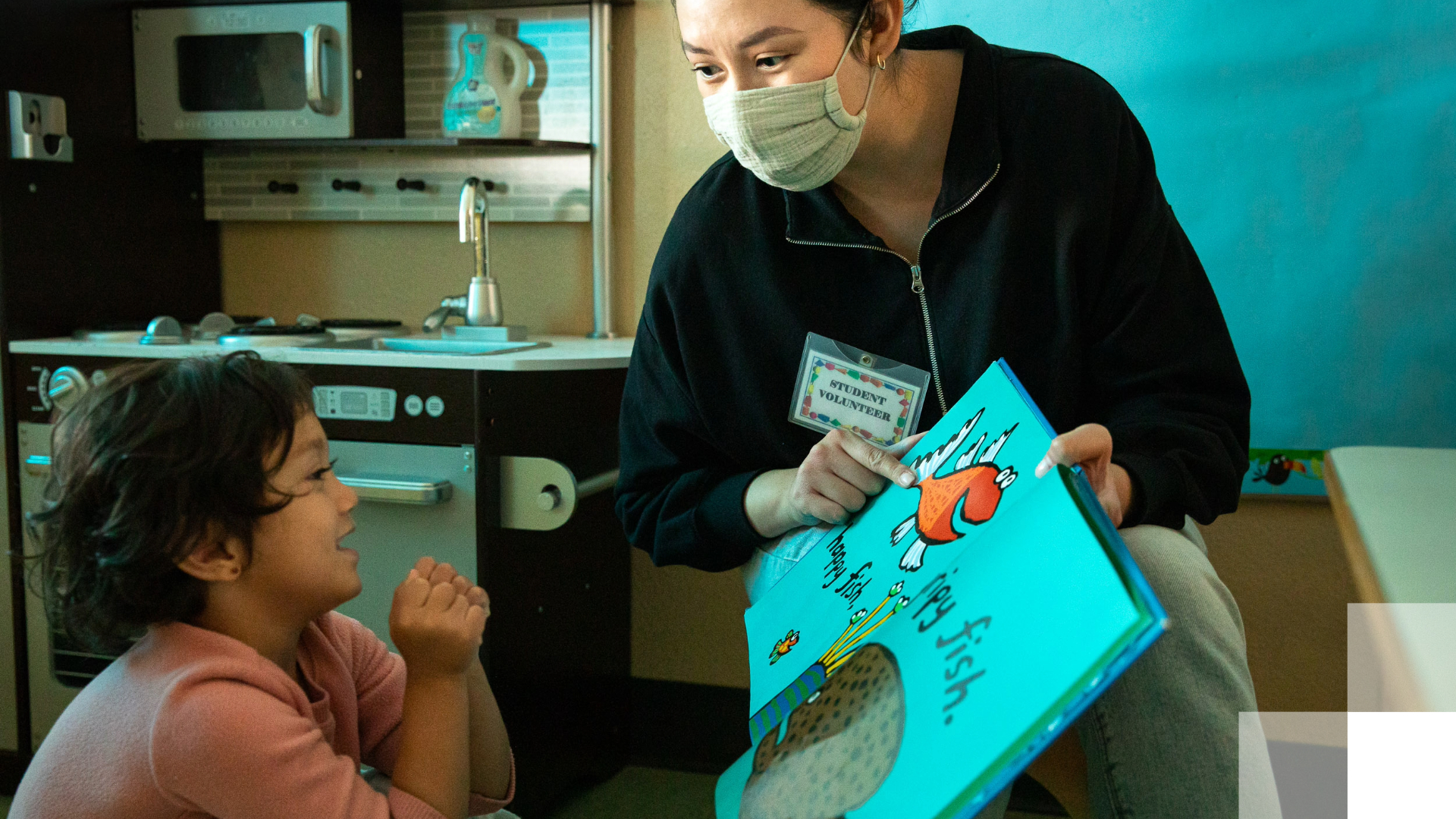 Ballmer Scholar Program Student volunteer reading a picture book to a young child