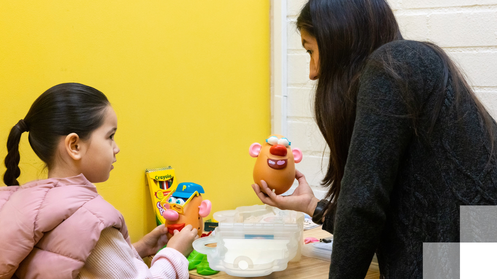 LB Teacher Residency Scholarships Adult and child playing with toys at a table.