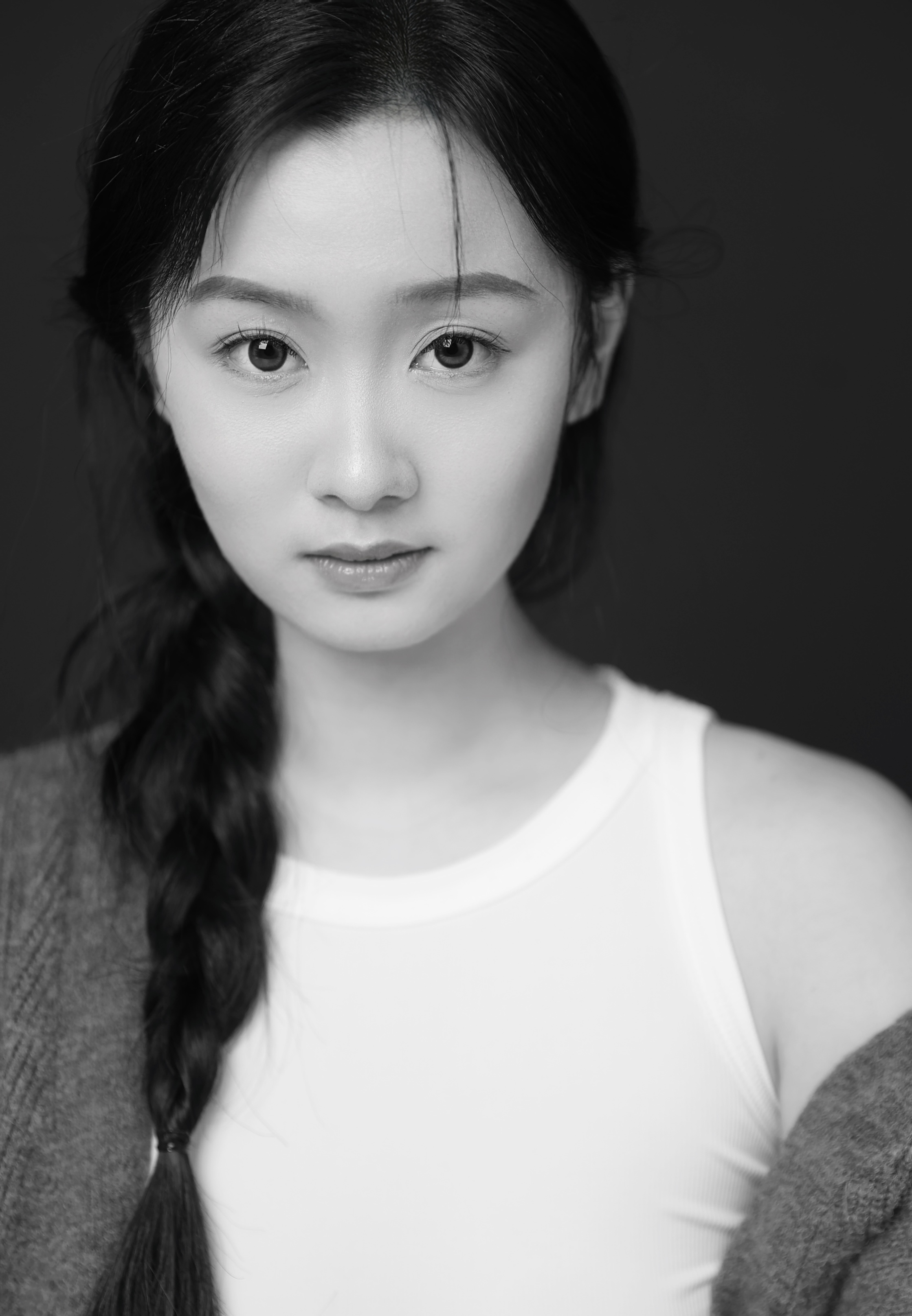 A black and white photo shows an asian woman posing into the camera