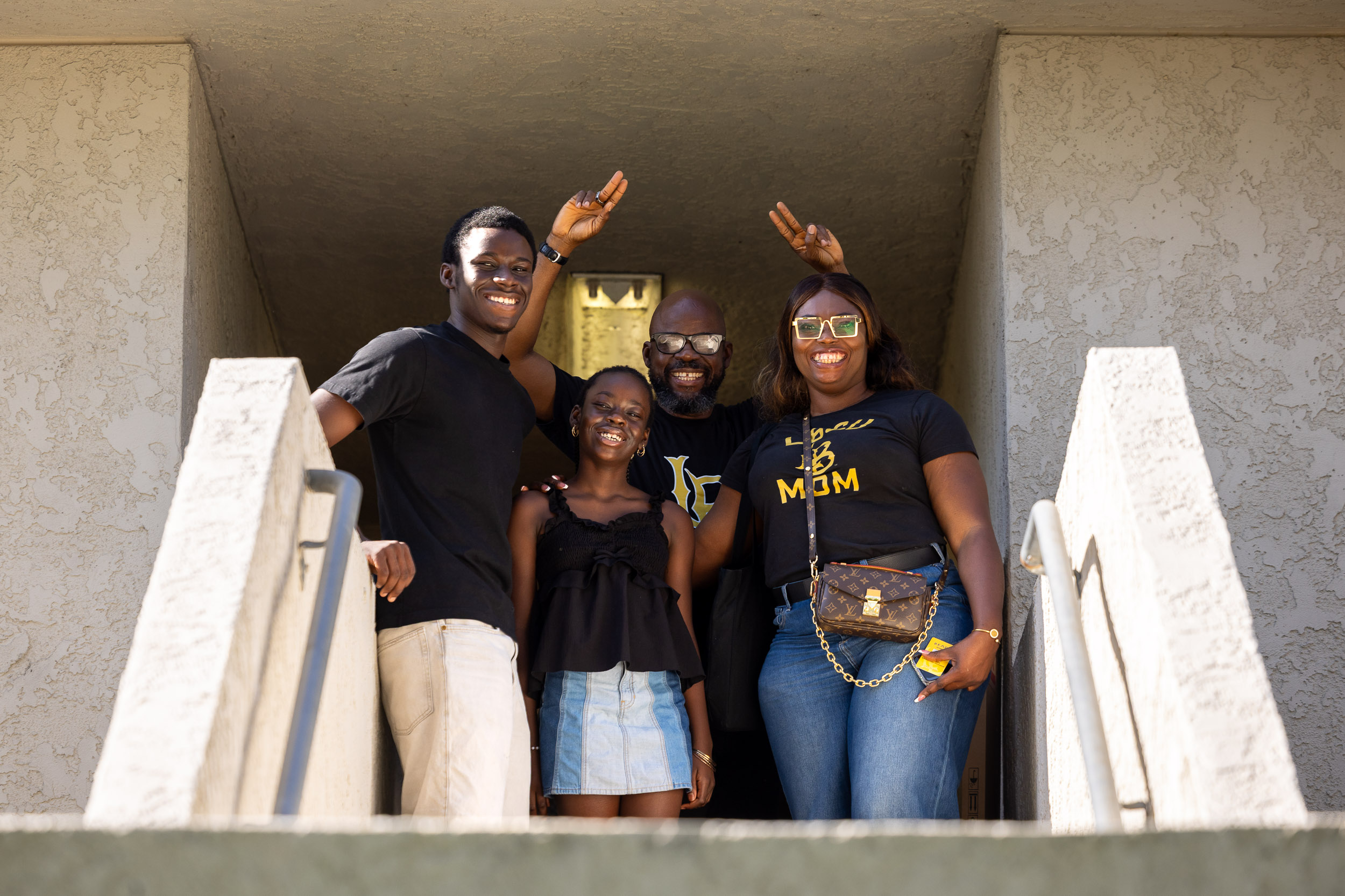 A family poses and smiles together on a staircase.