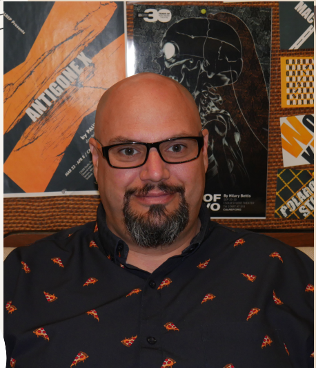 calrep bob a man with glasses and a beard smile into the camera. he is bald.