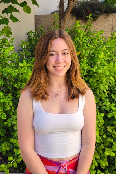 Elizabeth Forrey Elizabeth Forrey standing in front of a green bush