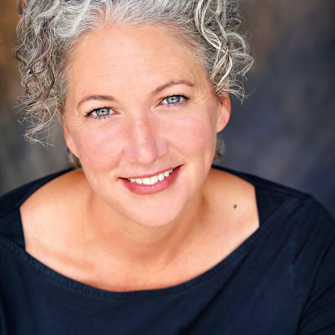 a woman smiles into the camera