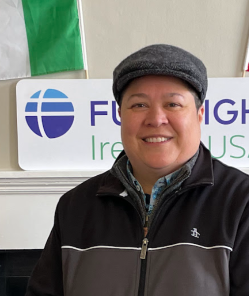 a person standing in front of a sign and flag