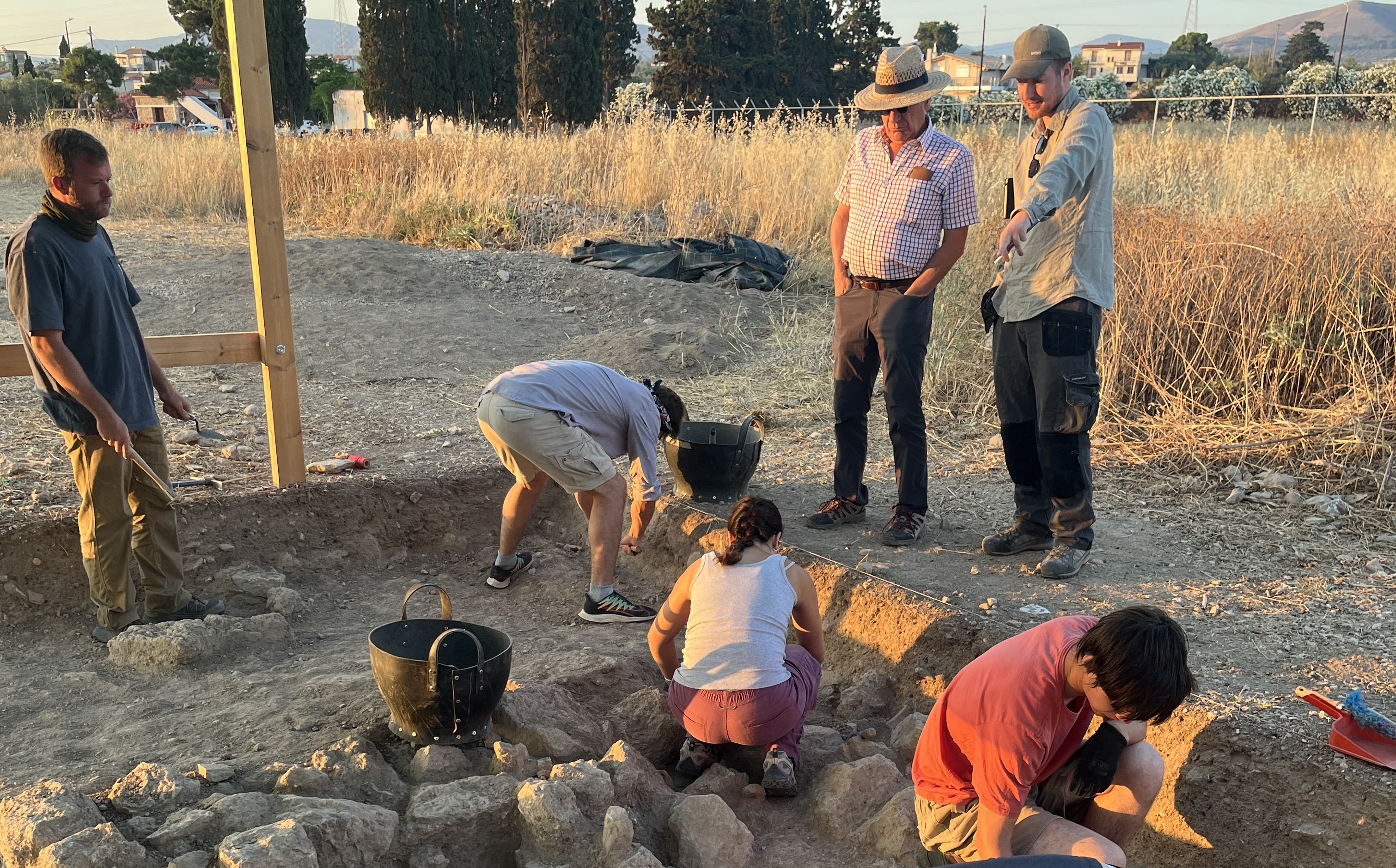 two people watching four people dig