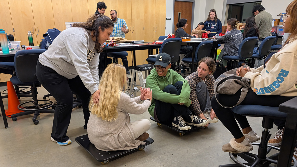 students using furniture dollies in a physics demonstration