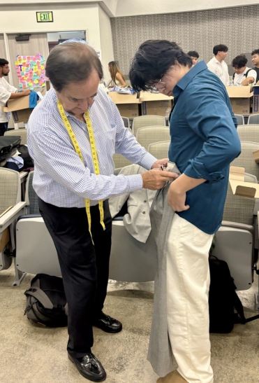 Cob Closet 2025 Professor assisting with clothing