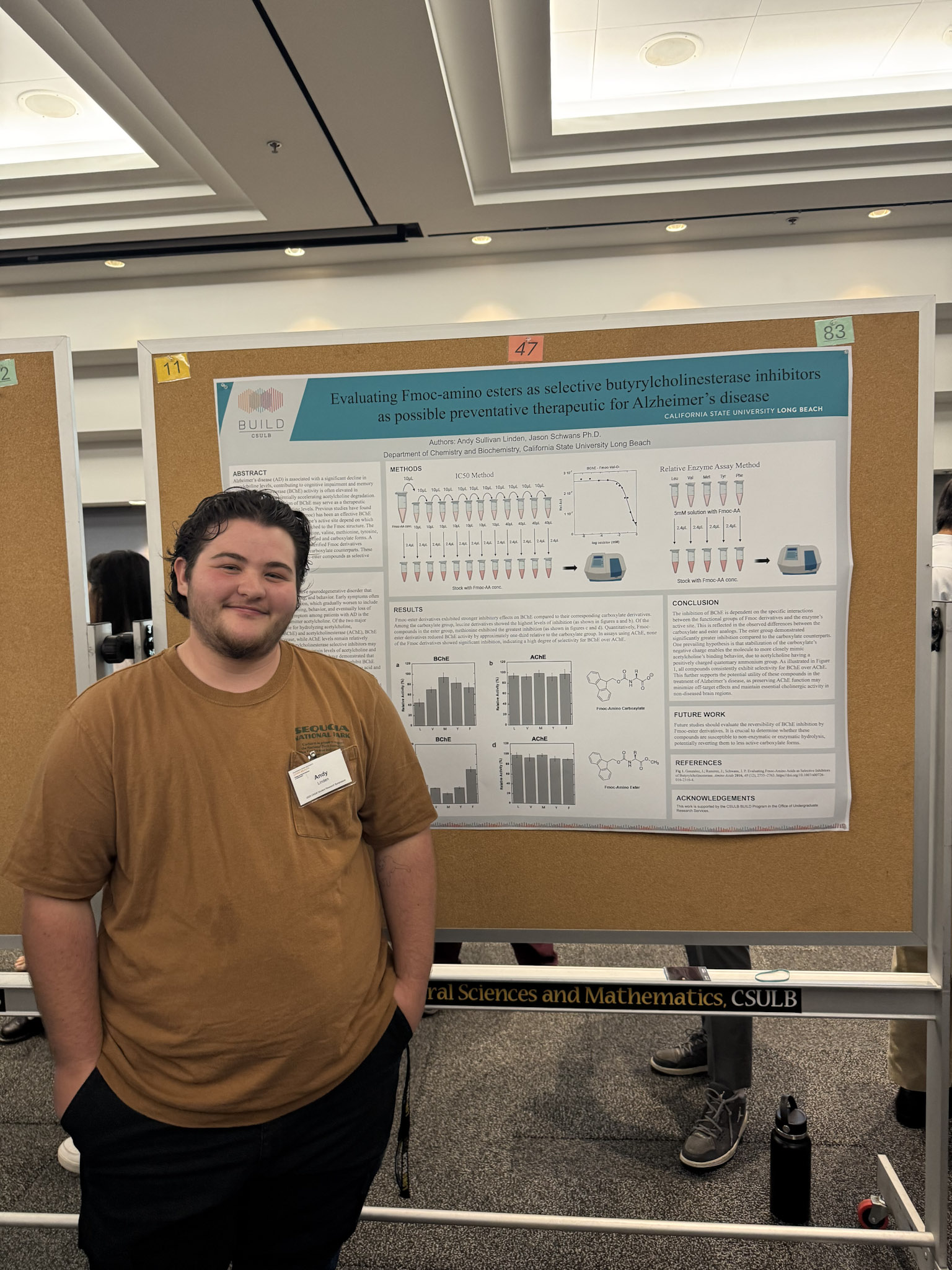 Presenter with black hair and brown shirt standing in front of research poster