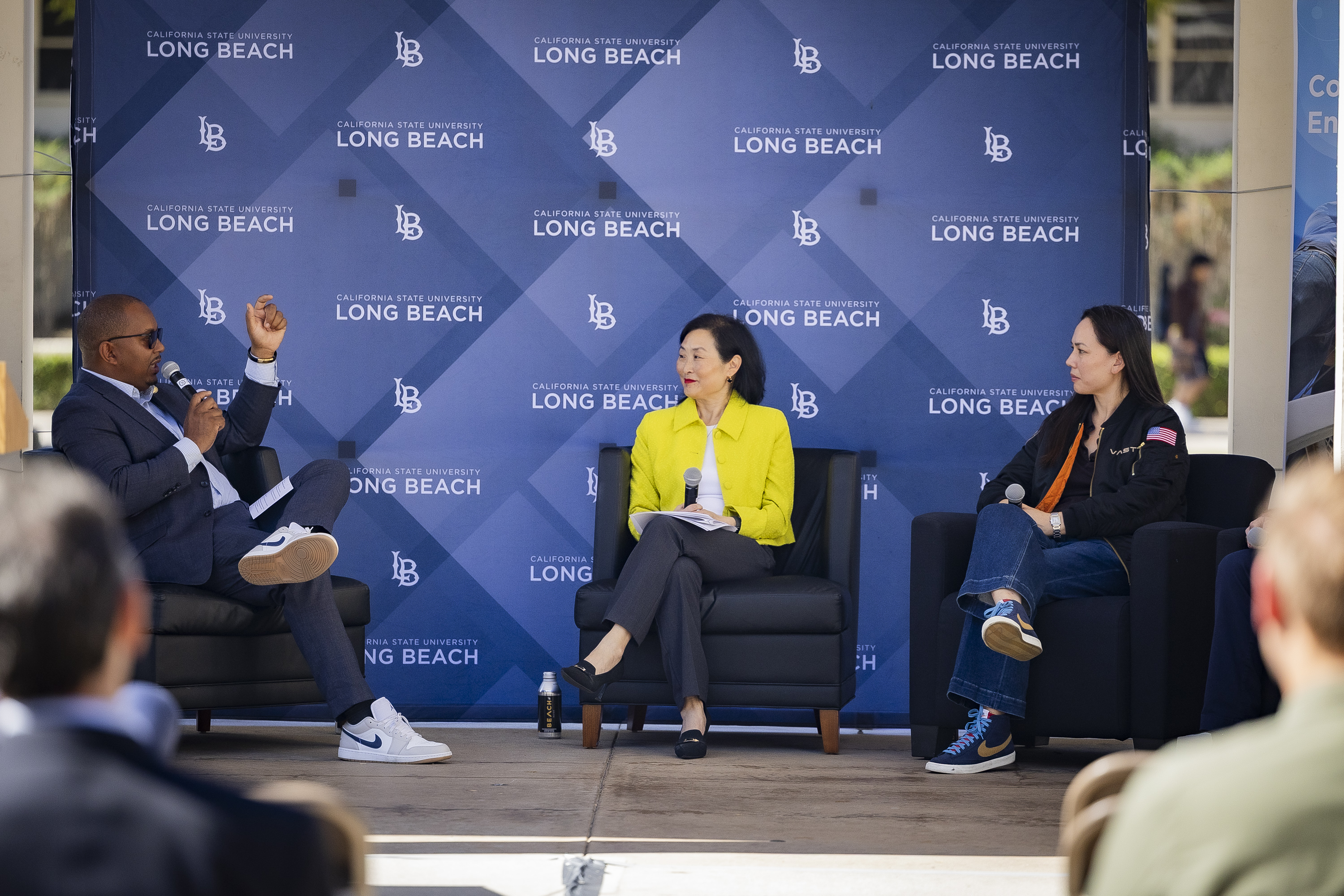 CSULB panel discussion Three speakers sit onstage in conversation during a California State University Long Beach event.