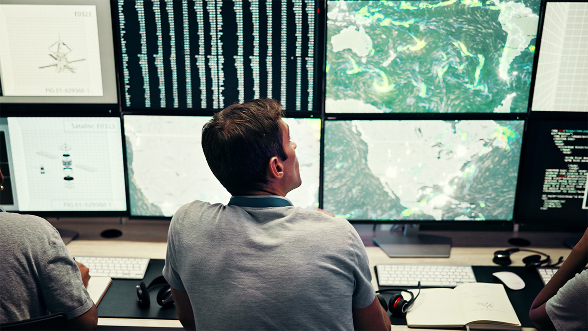 journalist looking at weather patterns on multiple screens