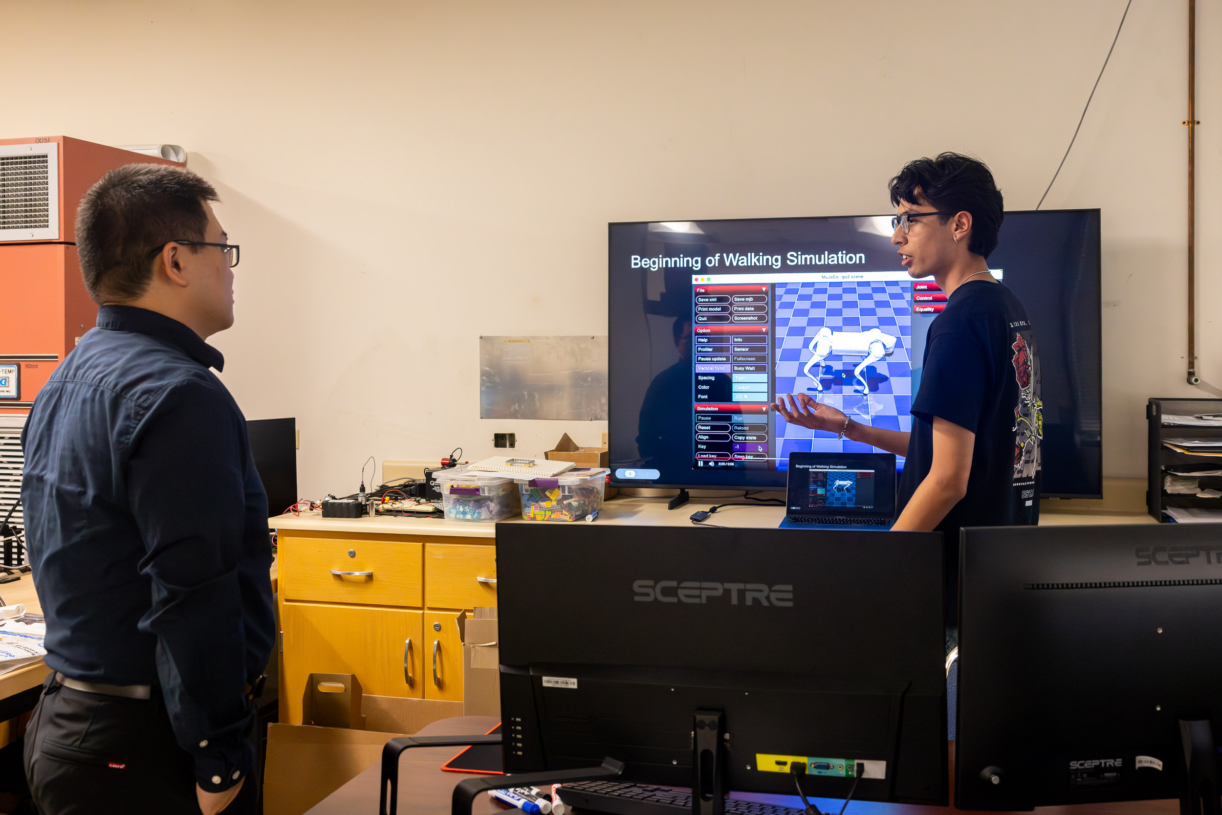 A person presents a walking simulation on a large screen to another person in a CSULB lab.
