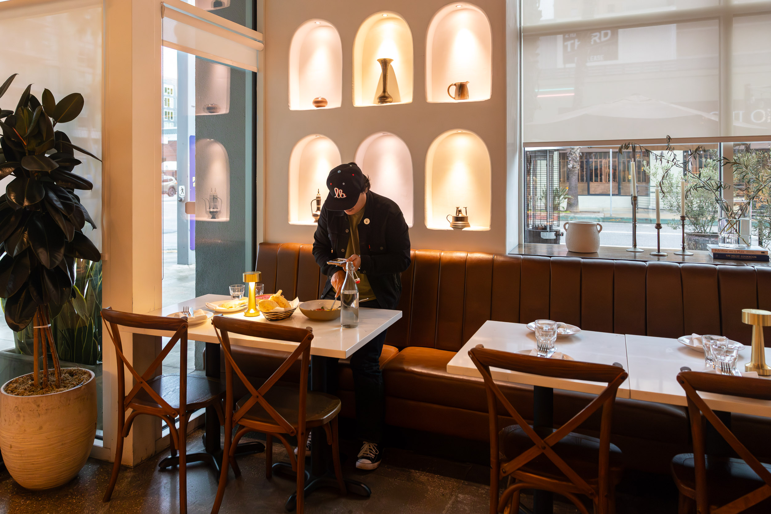 Person stands over bowl of food with iPhone