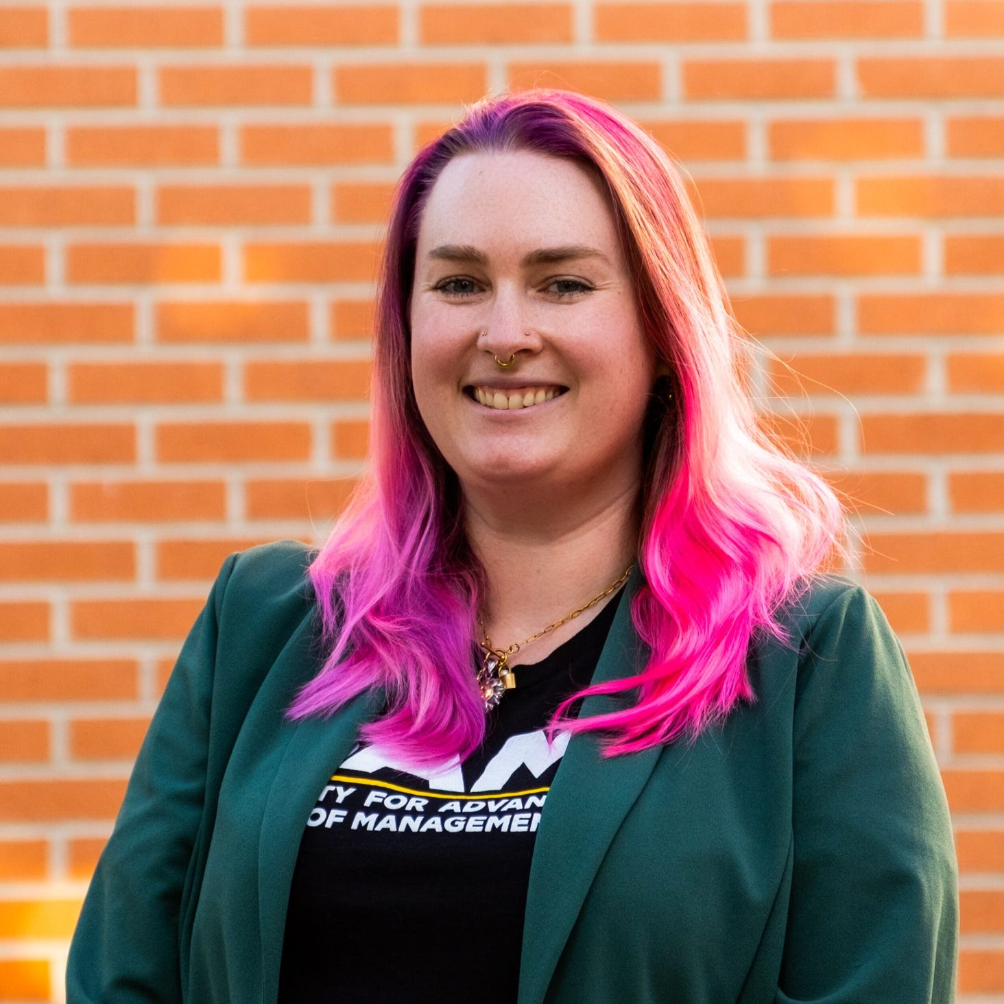 woman with pink hair wearing a green blazer