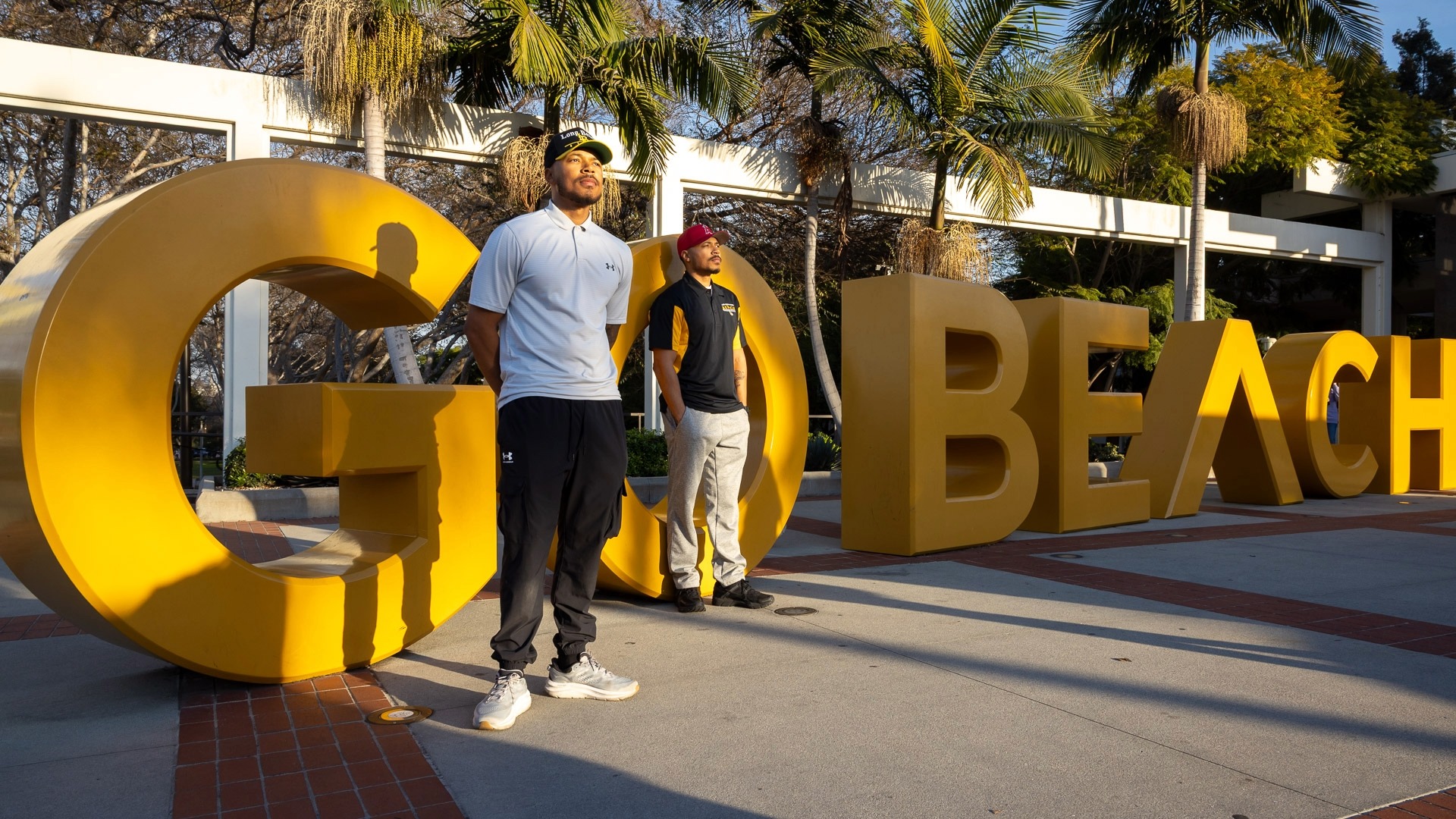 Markel and Martel Cooper ‘19 in front of the GO BEACH sign.