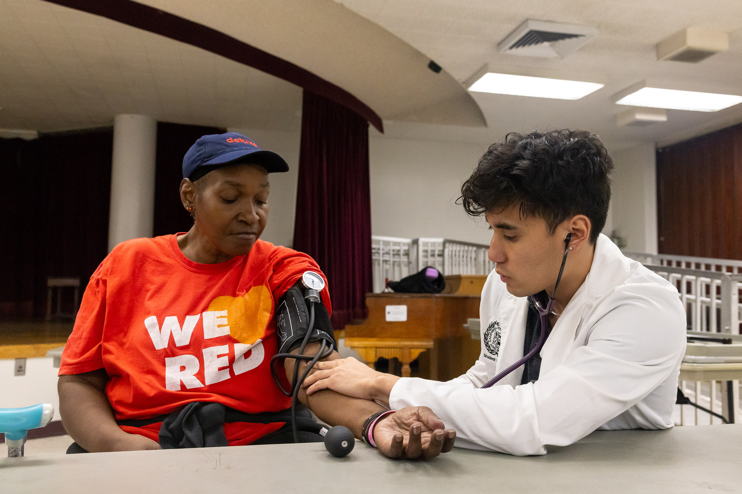 CSULB Nursing student gives blood pressure to community senior