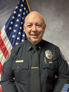 Lieutenant Sotelo headshot in front of American flag.