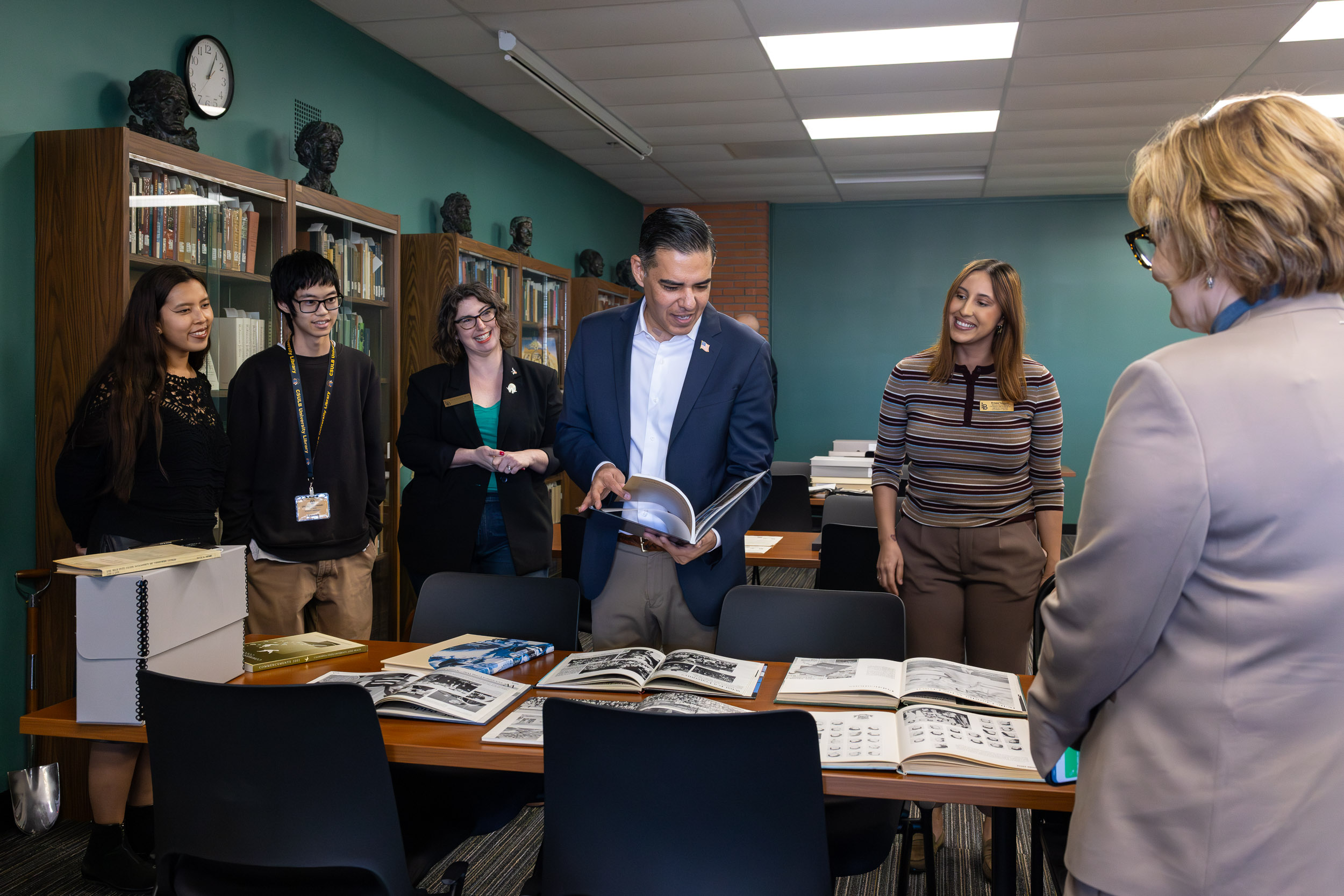 A person looks at a book while other people look on