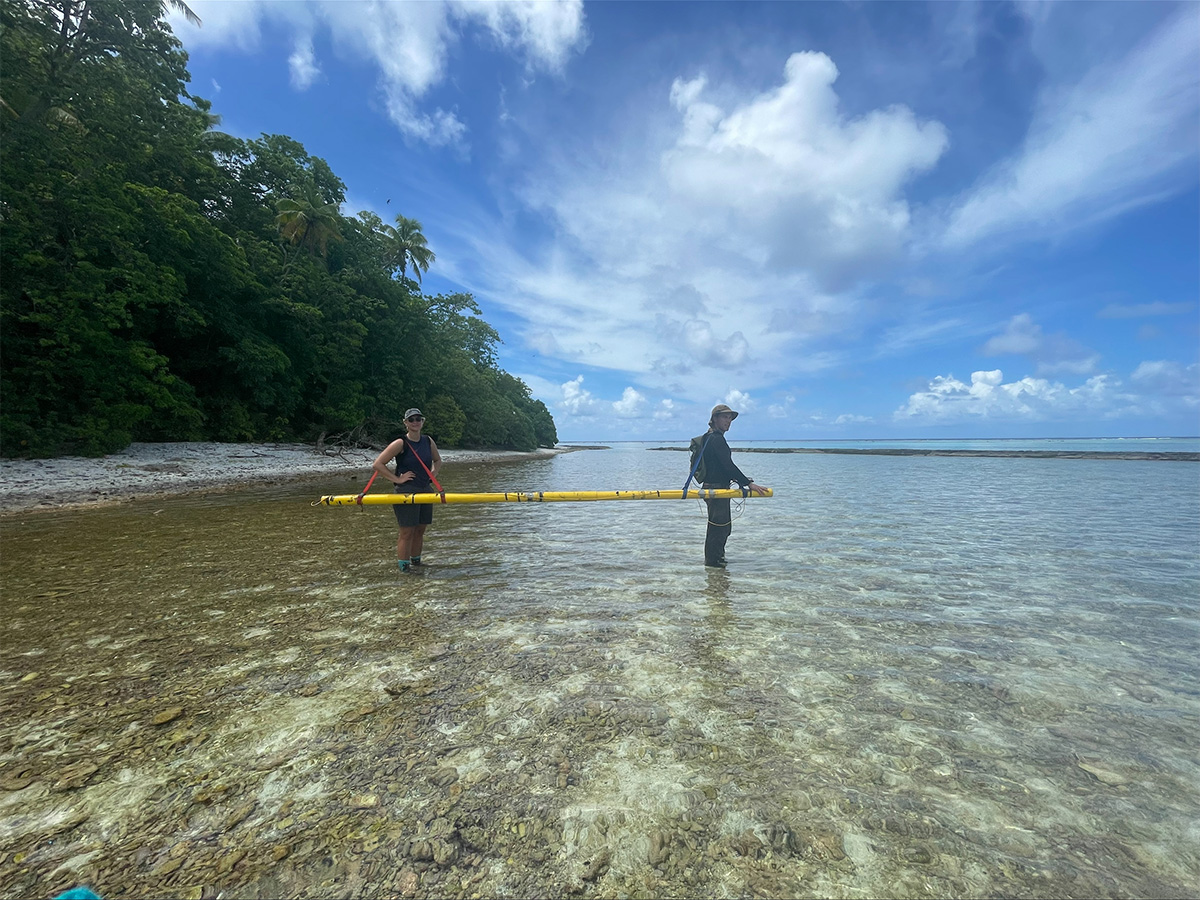 student researchers standing in shallow water and conducting a fdem survey