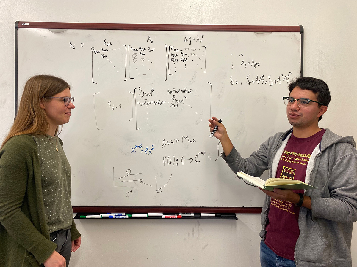 Diego explaining a concept in front of a whiteboard