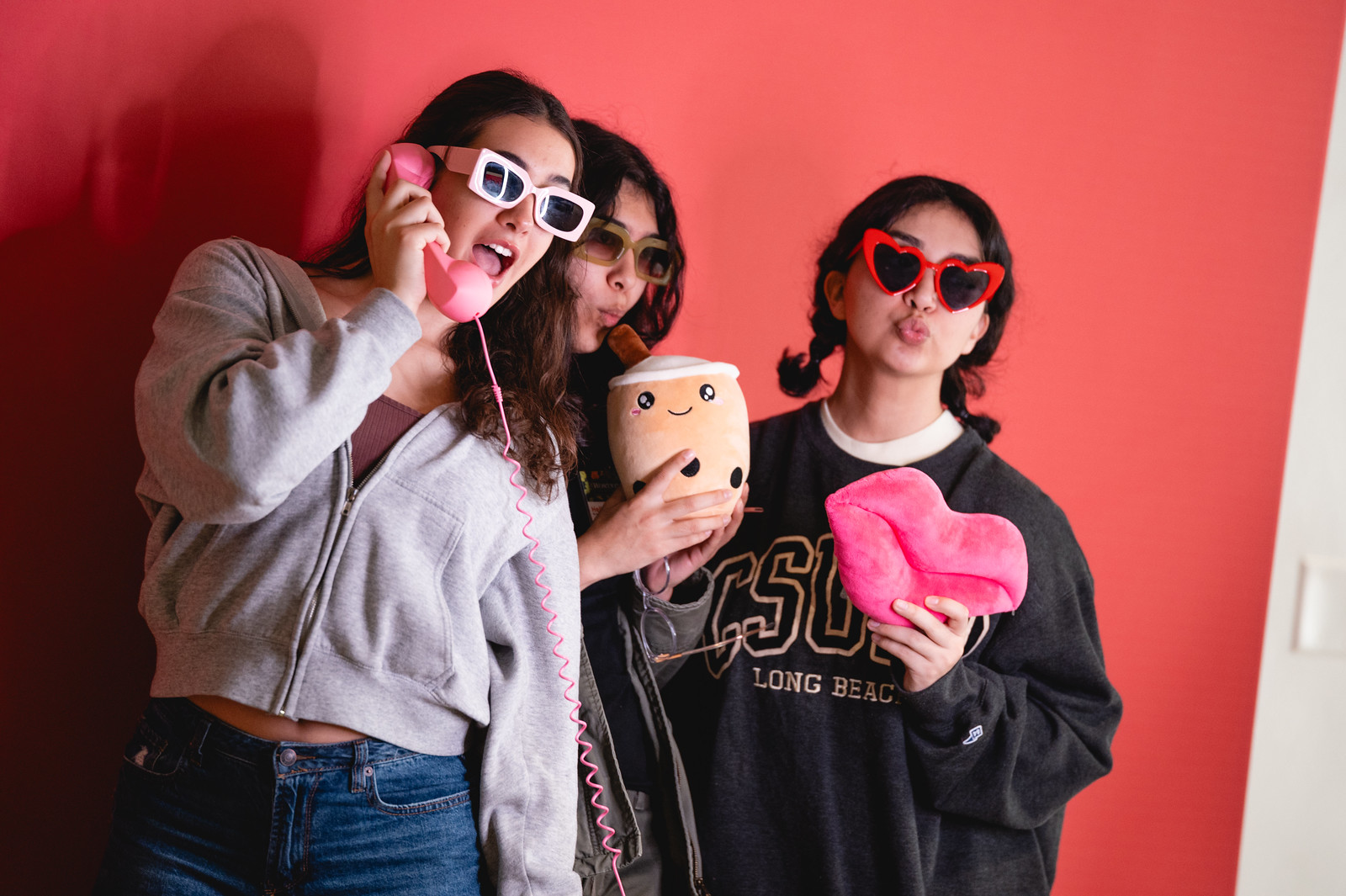 Three female attendees posing for photos in  a photobooth at the 2024 Womxn of Color Leadership Conference.